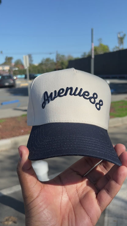 Cream & Navy blue cursive logo hat